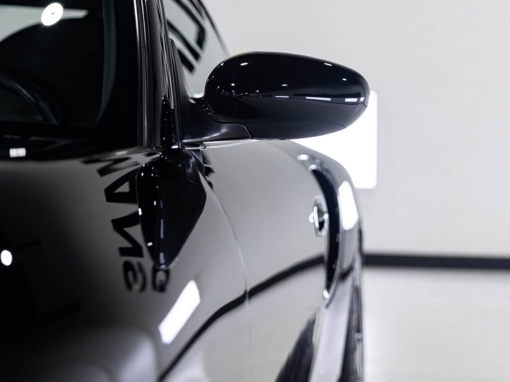 Side mirror of a black Porsche 911 Turbo with paint protection film